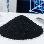 A mound of fine black iron oxide powder in a lab setting, illustrating the topic of the black iron oxide SDS and safety guide.